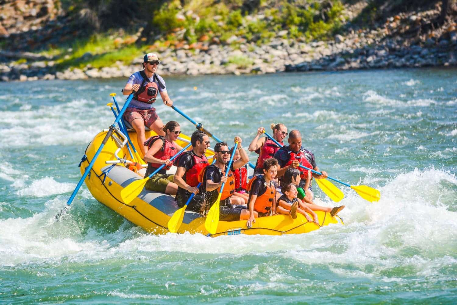 Group of adults and children whitewater rafting on the Yellowstone River